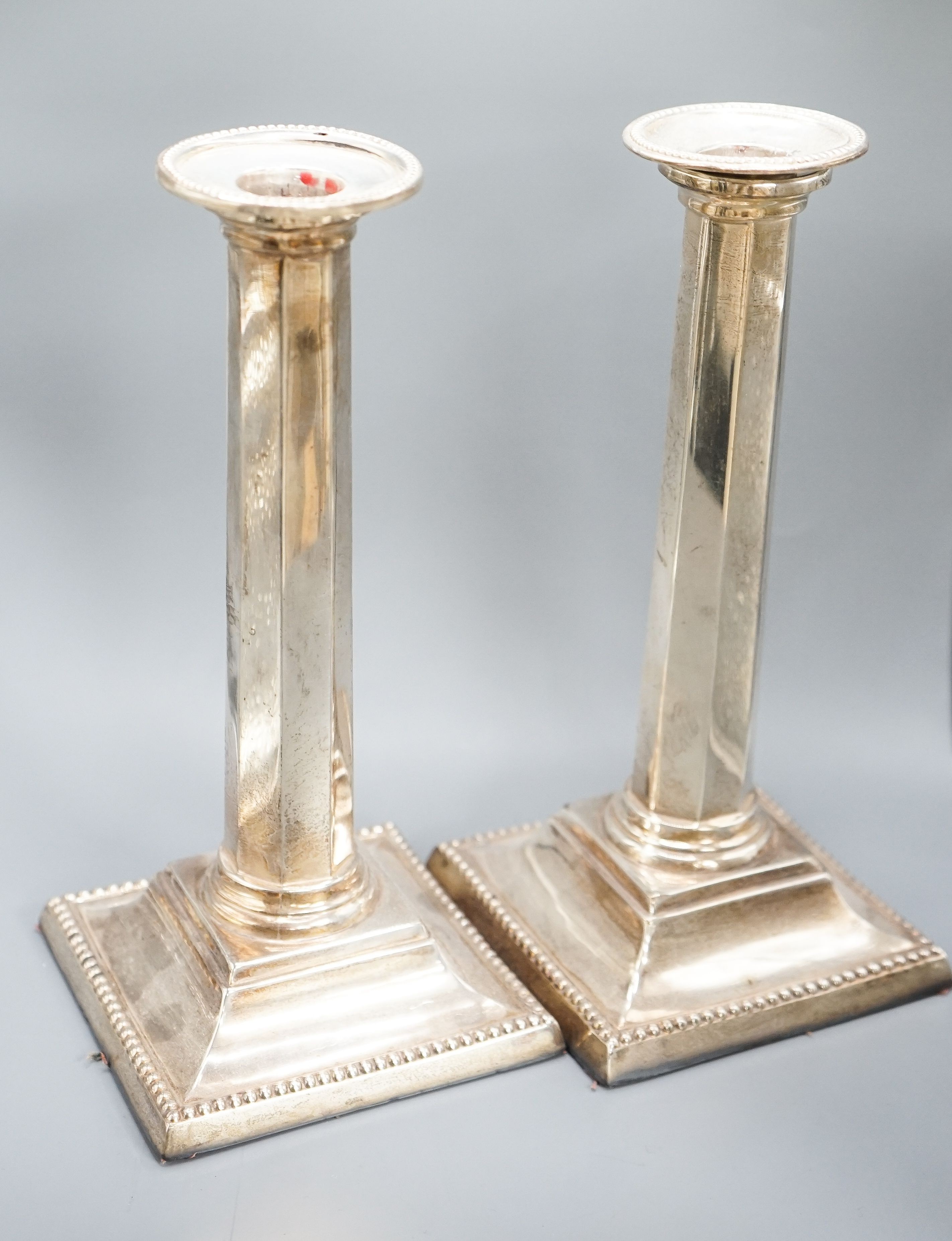 A pair of Edwardian silver candlesticks, with panelled columns, Birmingham, 1905, 20.8cm, weighted.